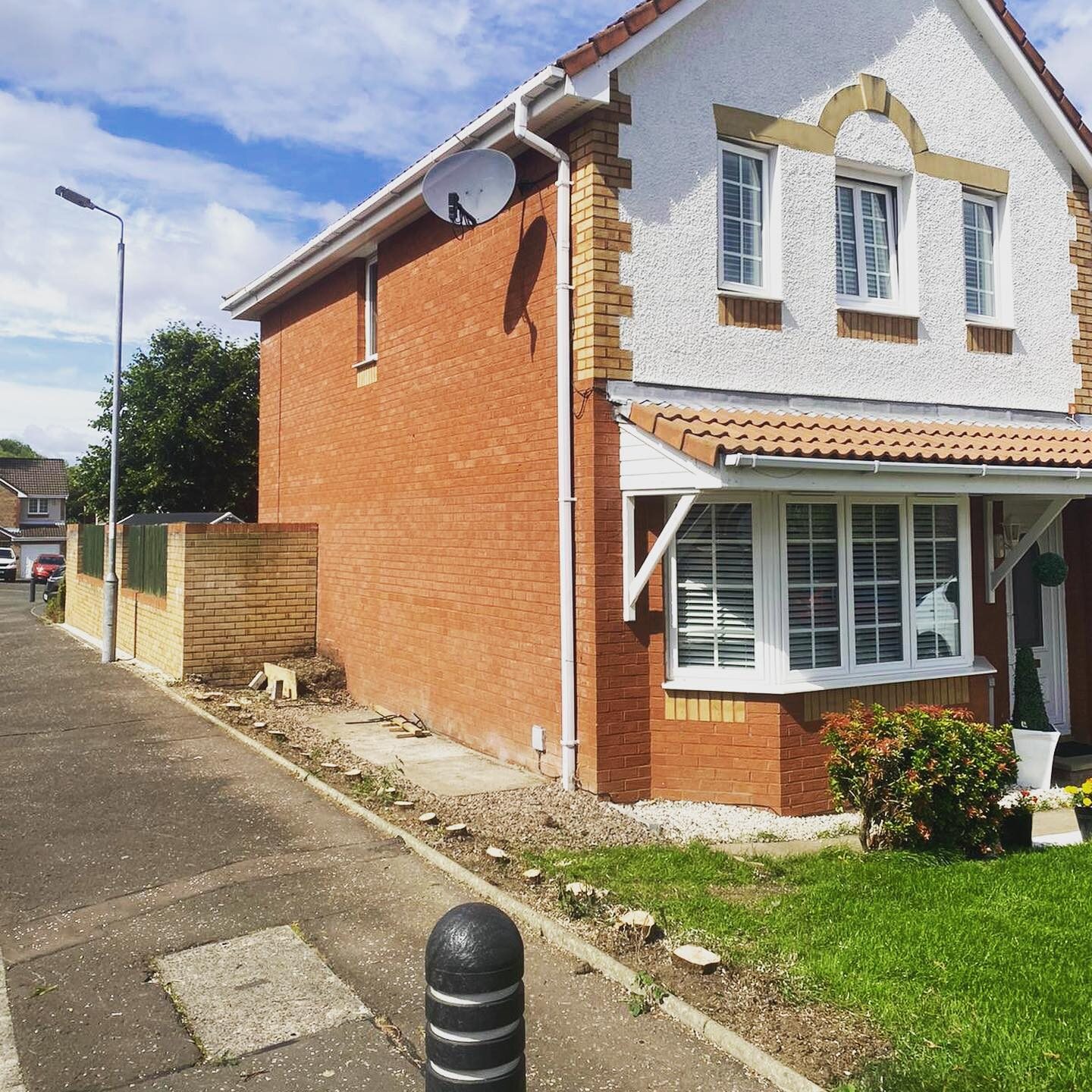 The same pavement with the hedge removed and the stumps ground out, the house now fully visible