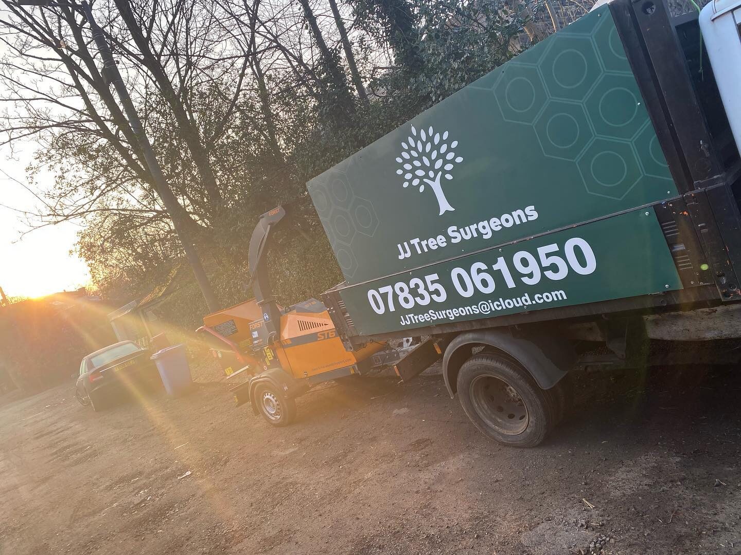 The green JJ Tree Surgeons tipper truck loaded up at sunrise